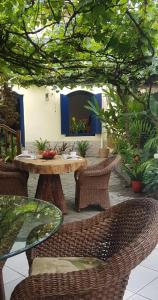 a patio with a table and wicker chairs and a table at Pousada Manga Rosa in Paraty