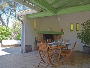 einen Tisch und Stühle auf einer Terrasse mit Kamin in der Unterkunft Lush Villa in Beaucaire with Swimming Pool in Beaucaire