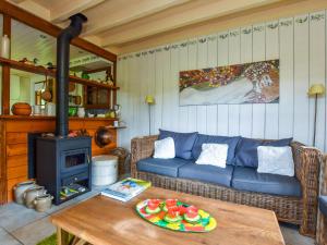 uma sala de estar com um sofá e um fogão a lenha em Holiday home in Miremont with garden em Saint-Jacques-dʼAmbur