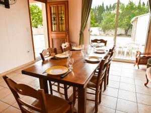 a dining room with a wooden table and chairs at Beautiful holiday home in Argeliers with pool in Argeliers