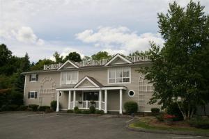 a large house with a balcony on top of it at The Central Downtown Inn Suites in Pittsfield