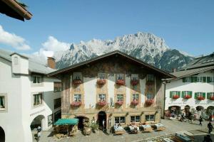 a large building with a mountain in the background at Alpenrose in Mittenwald