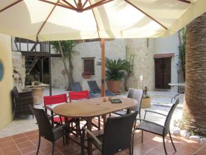 una mesa y sillas con una sombrilla en el patio en Attractive Villa in Giannoudi with Private Pool en Giannoudi