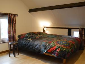 Nice gite with low ceilings in Han sur Lesse في هان-سور-ليس: غرفة نوم مع سرير وبطانية ملونة