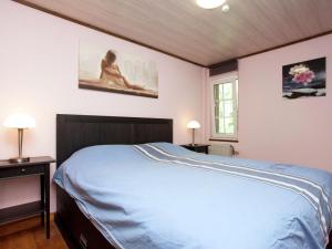 a bedroom with a bed and two tables and a window at Modern Chalet in Sougné-Remouchamps near Forest in Aywaille
