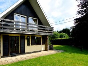 a house with a balcony on the side of it at Inviting chalet in the woods in Ovifat in Waimes