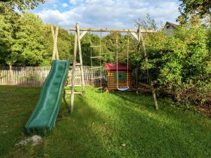 un parque infantil con un tobogán verde en un patio en Charming Holiday Home in Malmedy with Sauna en Malmedy