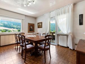 a dining room with a table and chairs and a window at Belvilla by OYO Fiamme Grande in Predazzo