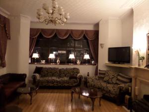 a living room with a couch and a tv at The Grays in Blackpool