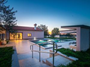 Beautiful Villa in Vrsar with Swimming Pool في فيرسار: مسبح في الحديقة الخلفية للمنزل