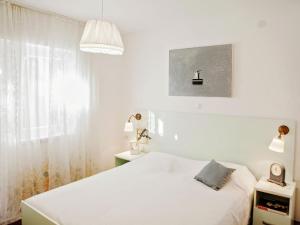 a white bedroom with a bed and a window at Cozy Apartment Brela in Brela