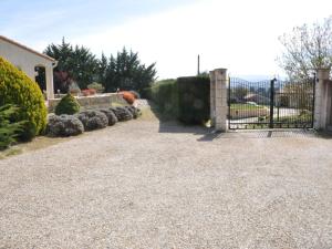 a driveway with a wrought iron gate and bushes at Luxury villa with pool in Malvi s in Malviès