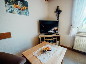 een woonkamer met een tafel en een televisie bij Apartment near the forest in Plankenstein in Plankenfels