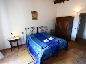 バニョレージョにあるElegant Farmhouse in Bagnoregio with swimming pool for 10 12 guestsのベッドルーム(青いベッド1台、テーブル付)