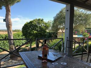 ナルボンヌにあるVilla with private pool and lake viewのワイングラス付きのテーブルに座ったワイン1本