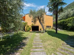 einen Steinweg, der zu einem Gebäude im Hof führt in der Unterkunft Belvilla by OYO Villa Olivella in Sale Marasino