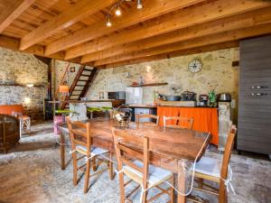 eine Küche und ein Esszimmer mit einem Holztisch und Stühlen in der Unterkunft Stone house in a vineyard, with swimming pool, near Bordeaux in Monprimblanc