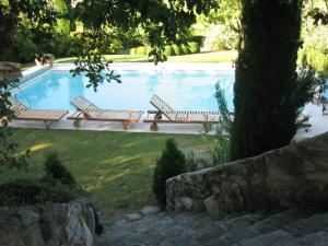 een zwembad met 2 ligstoelen ernaast bij Countryhouse with Pool in Vaison la Romaine in Vaison-la-Romaine