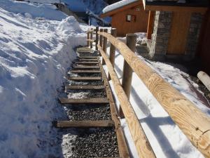 een trap in de sneeuw naast een gebouw bij Charming chalet with view on Mont Blanc in Peisey-Nancroix