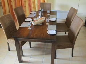 mesa de comedor de madera con 4 sillas y mesa y sillas de madera en Attractive villa with swimming pool in Les Forges, en Les Forges