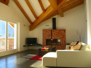 ein Wohnzimmer mit einem weißen Sofa und einem TV in der Unterkunft Belvilla by OYO Villa Stenico in Steinig