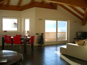 ein Wohnzimmer mit einem Tisch und roten Stühlen in der Unterkunft Belvilla by OYO Villa Stenico in Steinig