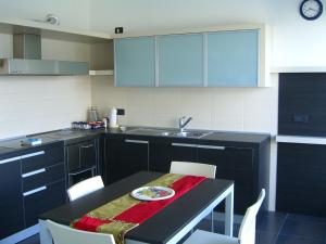 - une cuisine avec une table et une plaque de cuisson dans l'établissement Belvilla by OYO Villa Stenico, à Stenico