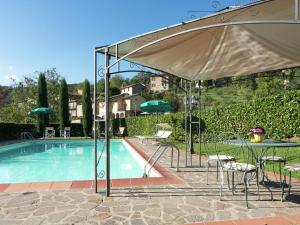 uma piscina com uma mesa e um guarda-sol em Belvilla by OYO Villa Lonanno em Pratovecchio