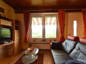 a living room with a couch and a window at Cozy Holiday Home in Boevange Clervaux with Garden in Boevange-Clervaux