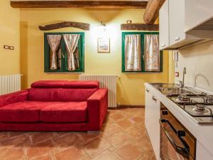 uma cozinha com um sofá vermelho e um fogão em In a green and relaxing atmosphere with pool and stunning lake view em Marone