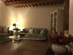 uma sala de estar com um sofá verde e uma mesa em Tuscan Farmhouse in Castiglione di Garfagnana with Garden em Castiglione di Garfagnana