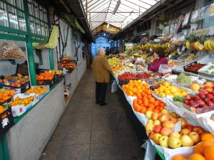 a man and woman standing in a market with fruits and vegetables at Hotel S. Gabriel in Porto