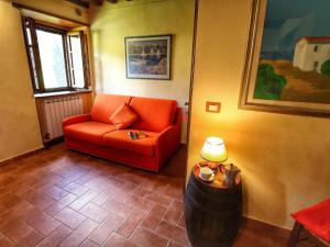 salon z pomarańczową kanapą i stołem w obiekcie Belvilla by OYO Farmhouse in Radda with Garden w mieście Radda in Chianti