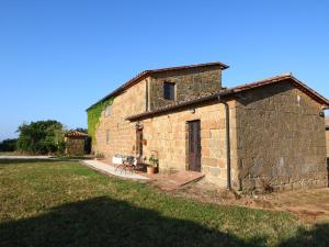 a small brick building with a grass field in front of it at Belvilla by OYO Piano in Sorano