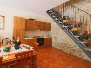 ApecchioにあるBelvilla by OYO Rosa Biancaのキッチン(ダイニングテーブル、階段付)