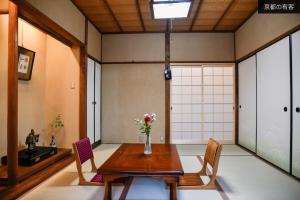 a room with a table and chairs with a vase of flowers at 京都有客 in Kyoto
