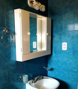 bagno con lavandino e armadietto dei medicinali di Ruta 20 HOUSE Quines a Quines