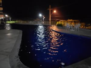 ein Pool mit Stühlen und Lampen in der Nacht in der Unterkunft Le bon vivant 305 in Arraial do Cabo