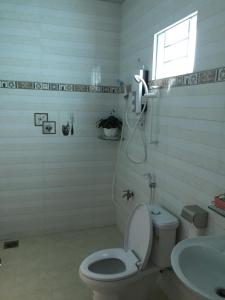 a bathroom with a toilet and a sink and a window at HÒANG HÔN HOMESTAY in Ben Tre