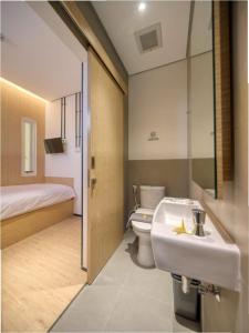 a bathroom with a sink and a toilet and a bed at Cool Living in Jakarta +23 photos