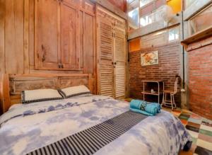 um quarto com uma cama grande e uma parede de tijolos em Lorong Homestay em Bantul