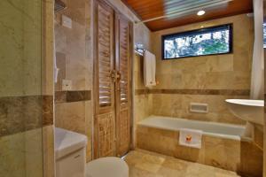 un bagno con vasca, WC e lavandino di Jayakarta Hotel Lombok a Senggigi