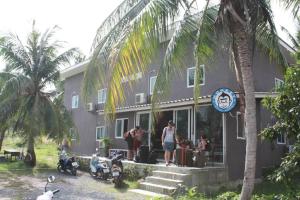 a group of people standing outside of a building at Monkey Samui Hostel in Choeng Mon Beach