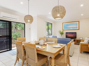 a dining room and living room with a table and chairs at 2 11a Christmas Bush Avenue - fantastic pet friendly townhouse close to Dutchies Beach with Wi-Fi and Air Con in Nelson Bay