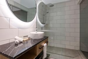 uma casa de banho com um lavatório e um espelho em Hotel Room @ 89 Courtenay Place em Wellington
