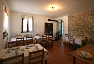 a restaurant with tables and chairs and a stone wall at B&B La Fenice in Montegridolfo