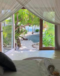a room with a view of a beach with a tent at Samura Maldives Guest House Thulusdhoo in Thulusdhoo