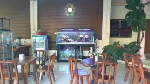 a dining room with a table and chairs and a fish tank at The 99 Inn Hotel in Ban Sao Thong