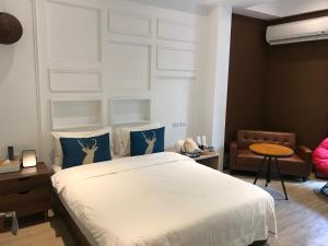 a bedroom with a white bed with blue pillows at Chi Chu B&B in Taitung City