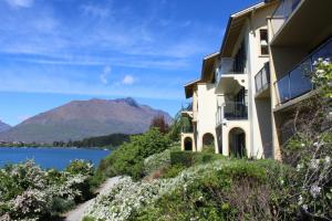 a building with a view of a lake and mountains at Villa Del Lago in Queenstown